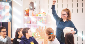 Een pedagogisch coördinator van TADA steekt haar hand op om de aandacht te trekken